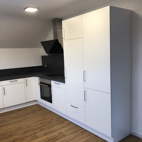 Einbaukühlschrank zwischen einem Schrank und einem Herd