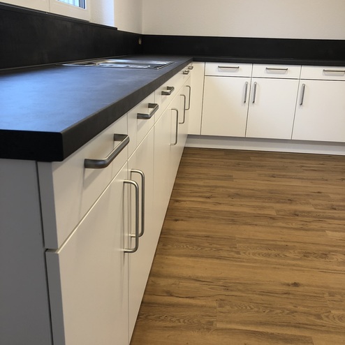 Detailaufnahme einer Einbauküche mit schwarzer Arbeitsplatte