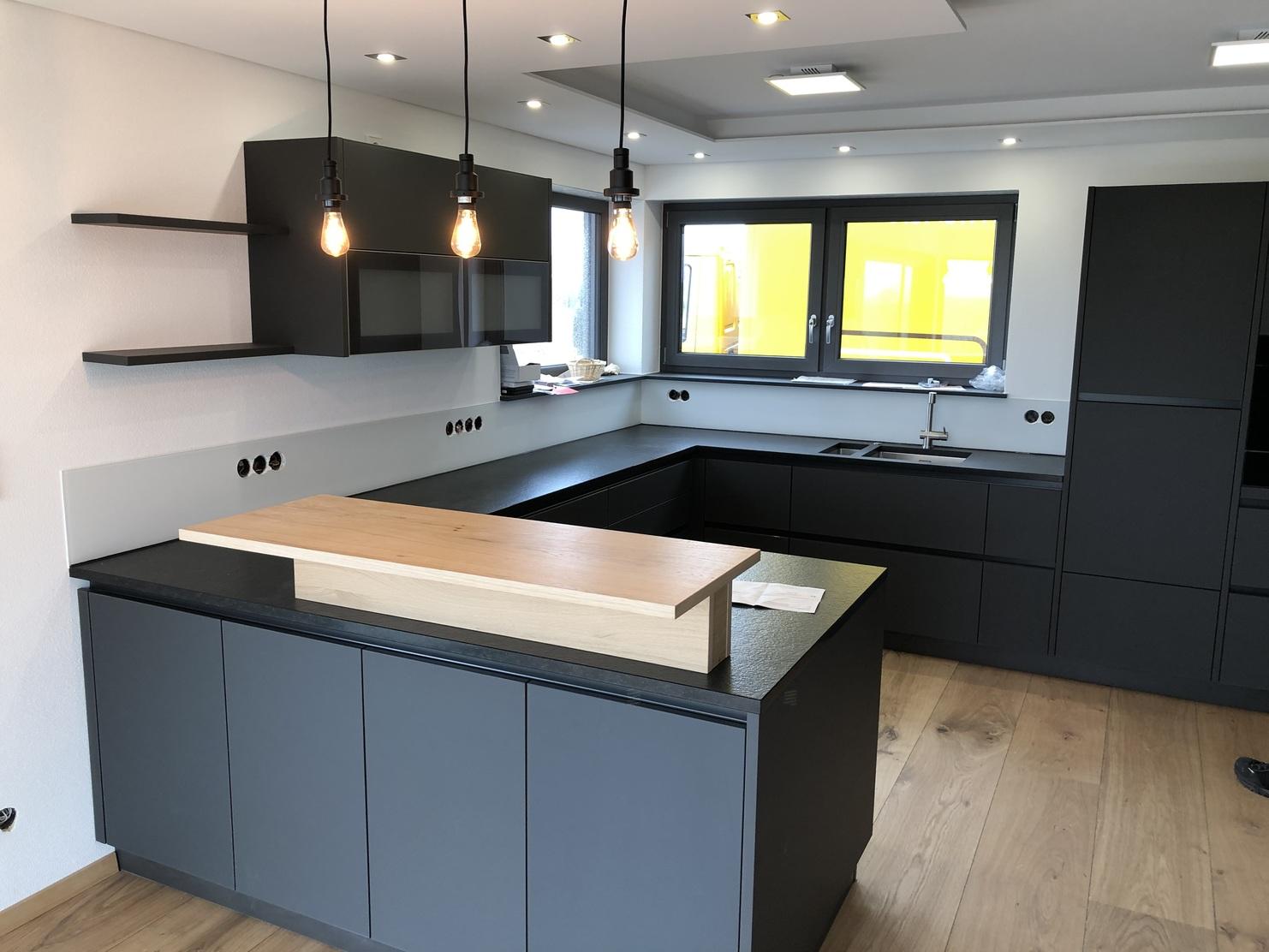 Geräumige Einbauküche mit schwarzen Fronten und Oberflächen