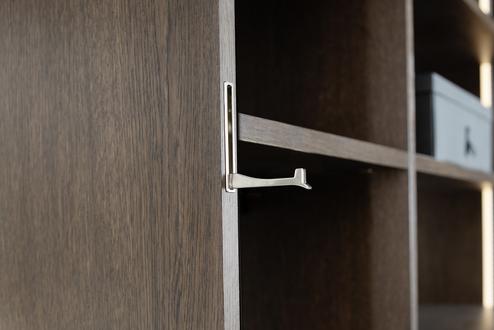 Eingelassener Klapphaken in Holz Eingelassener Metall-Klapphaken in einer Ankleide nach Maß, gefertigt aus dunklem Holz von Kallenberger.