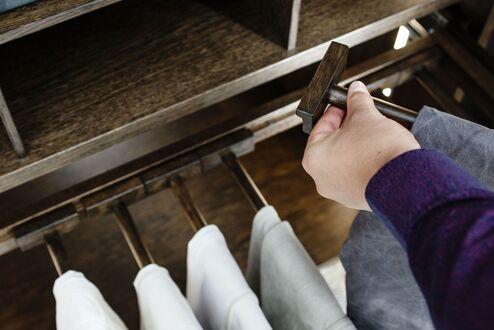 Holzdetail einer Maß-Ankleide Detailaufnahme eines hölzernen Kleiderauszugs in einer Ankleide nach Maß aus der Schreinerei Kallenberger.