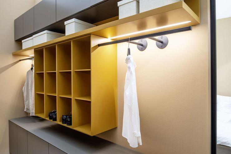 Gelbes Regalsystem mit Kleiderstange Modernes gelbes Regalsystem mit Kleiderstangen und Ablagen