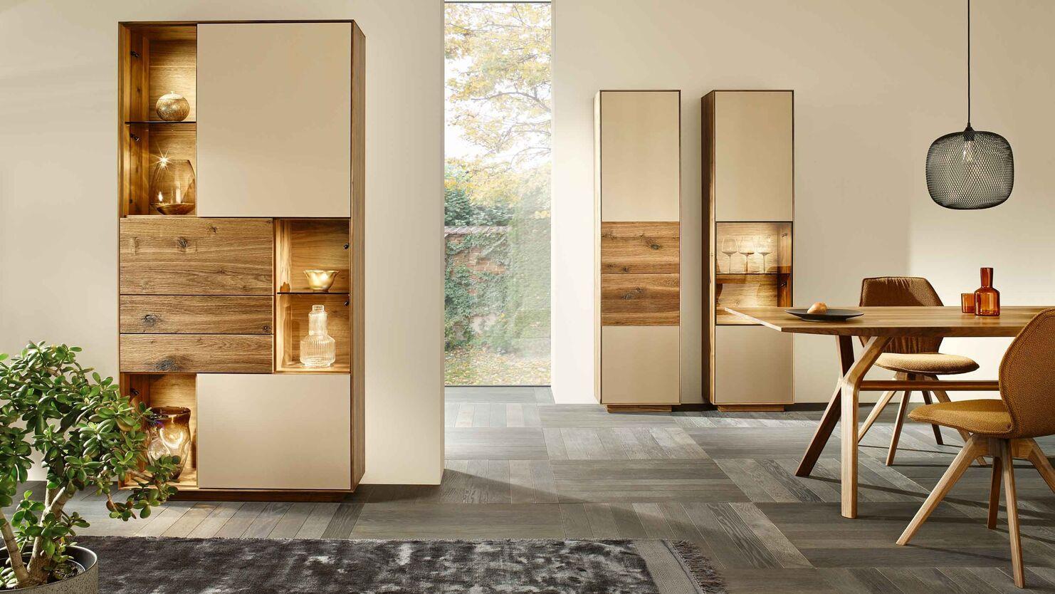 Elegantes Esszimmer mit Vitrinenschrank Stilvolles Esszimmer mit Holztisch, Vitrinenschränken und warmem Lichtdesign in natürlicher Atmosphäre.