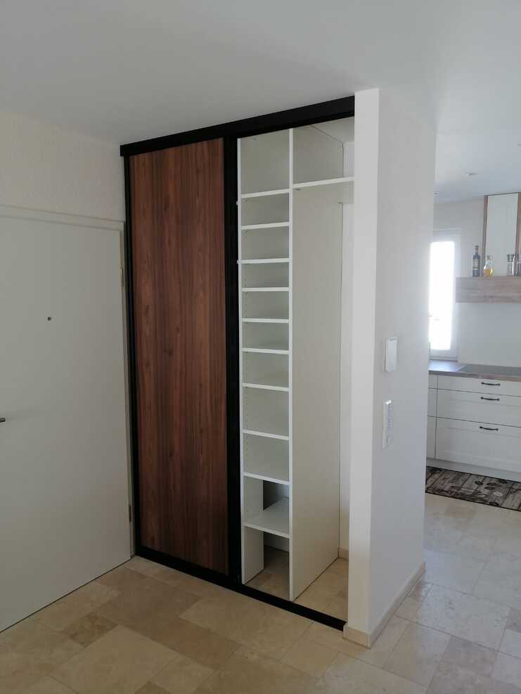 Einbauschrank in Holz-Weiß-Kombination Offener Einbauschrank mit Holzfronten und weißen Regalfächern, funktional gestaltet für modernen Wohnraum.